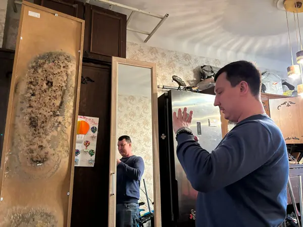 Эксперт осматривает шкаф, повреждённый водой